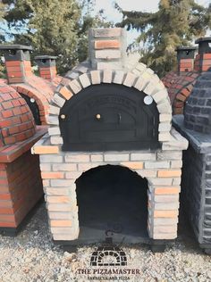 an outdoor brick pizza oven in the middle of gravel