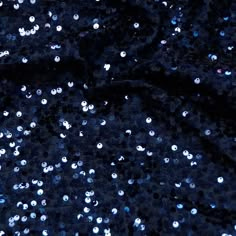 blue sequins on black fabric with lots of small white dots in the center