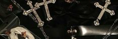 two crosses are attached to the back of a black purse with chains hanging from it