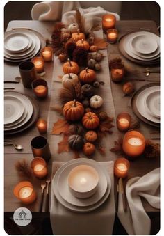 the table is set with white plates and candles