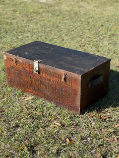 an old wooden box sitting in the grass