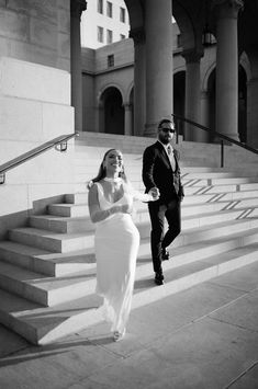 a man and woman are walking down the stairs