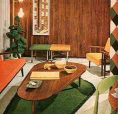 a living room with wood paneling and green furniture in the center, along with a painting on the wall