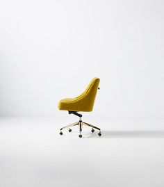 a yellow office chair sitting on top of a white floor