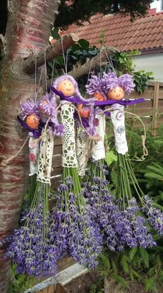 some purple flowers hanging from the side of a tree