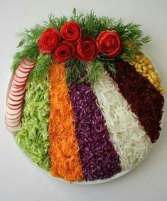 a plate filled with vegetables and flowers on top of a white tablecloth next to candy canes