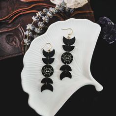 the black and white earrings are sitting on a plate