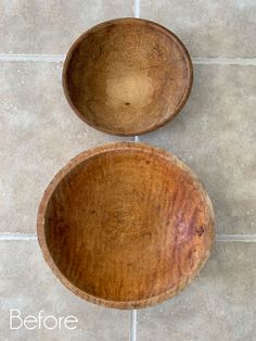 two wooden bowls sitting on top of a tile floor next to each other, one empty