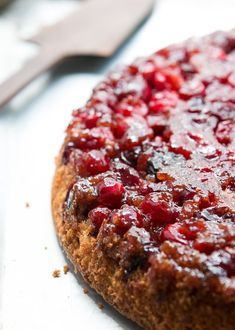 a cake with cranberry sauce on it sitting next to a knife and fork