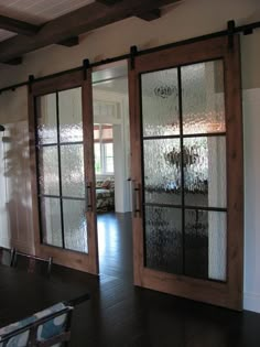 an empty room with glass doors and chairs