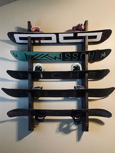 a snowboard rack mounted to the side of a wall with skis on it