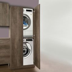 a washer and dryer are in the corner of a room with wood cabinets