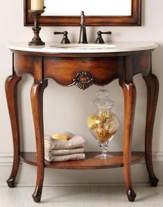 a bathroom with a sink and mirror on the wall next to towels, candles and other items