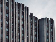 a very tall building with many windows on it's sides and a clock at the top