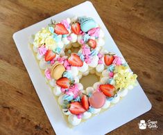 a white plate topped with a cake covered in frosting and strawberries on top of it