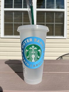 a plastic cup with a straw sticking out of it sitting on top of a table