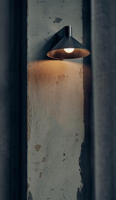 a light that is on the side of a wall in front of some concrete walls