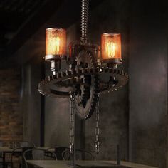 an industrial style chandelier with two lights and gears hanging from it's sides