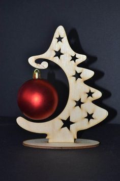 a wooden christmas tree with a red ornament