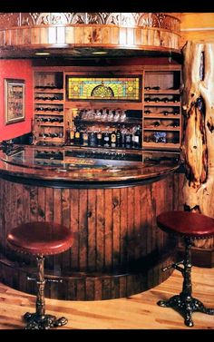 an old fashioned bar with stools in the corner and wood paneling on the walls