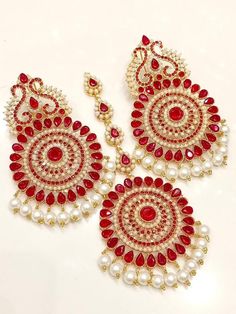 a pair of red and white beaded chandelier earrings with pearls on them