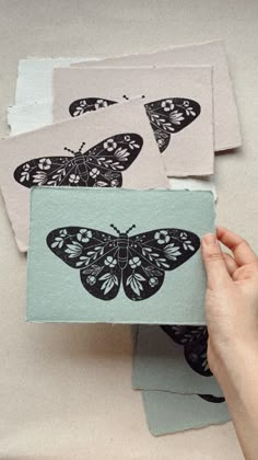 a person holding a piece of paper with some butterflies on it