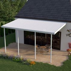 a small white house with a patio and table