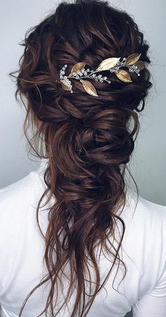 a woman with long brown hair wearing a gold leaf headpiece on top of her head