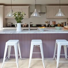 three white stools in front of a kitchen island