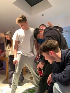 a group of young men standing around a cake