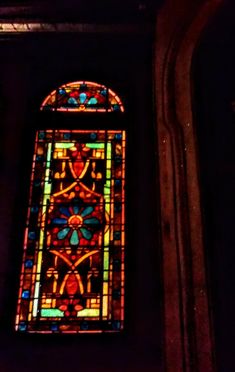 a stained glass window in a dark room