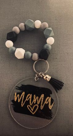 a bracelet with the word mama written on it and a tassel charm attached to it