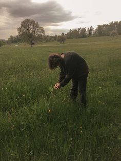 a person in a field picking something off the ground