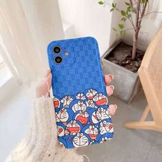 a person holding up a phone case with cartoon characters on it