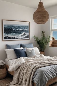 a bed sitting under a window next to a painting on the wall in a bedroom