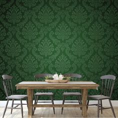 a dining room table with chairs and a green wallpaper