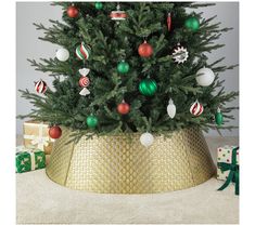 a small christmas tree in a gold pot with ornaments on the top and below it