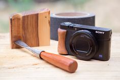 a wooden object next to a camera on a table