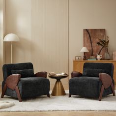 a living room with two chairs and a table in front of a wall that has vertical blinds