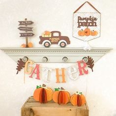 there is a sign that says gather and some pumpkins