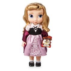 a doll with blonde hair and blue eyes wearing a pink dress, holding a toy penguin