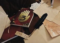 a table topped with lots of old books and writing paper on top of each other