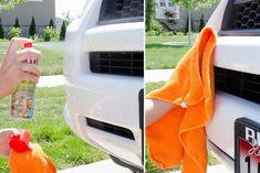 someone is cleaning the hood of a white car with orange towel and spray on it