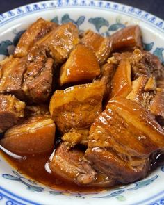 a bowl filled with meat and sauce on top of a table