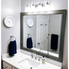 a bathroom with a large mirror and two towels hanging on the wall next to it