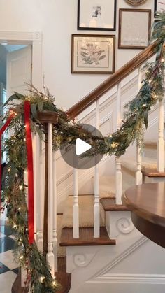 christmas garland on the banisters and stairs in a house with pictures above it