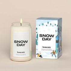 a candle that is next to a box on the ground with snow day written on it