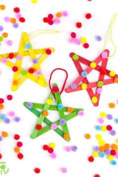 three wooden stars are hanging from string and confetti