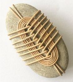 an object made out of rocks with wooden sticks sticking out of the top and on it's sides