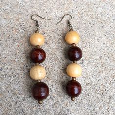 two pairs of wood and glass bead earrings on concrete surface with earwires